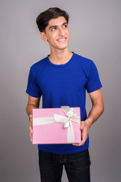 Genç yakışıklı İranlı genç çocuk hediye kutusu holding - Fotoğraf, Görsel