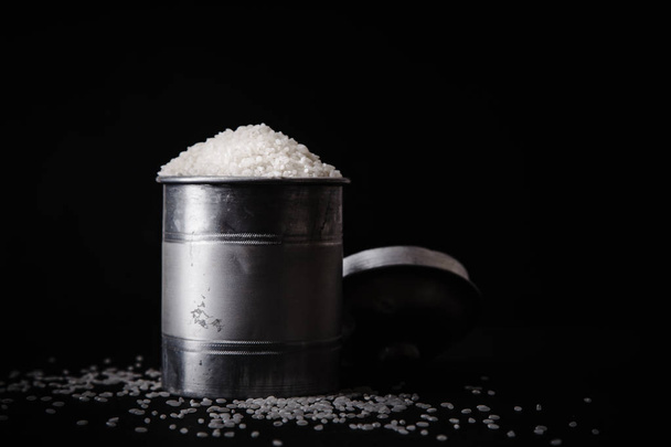 Arborio rice in metallic tin on black background - 写真・画像