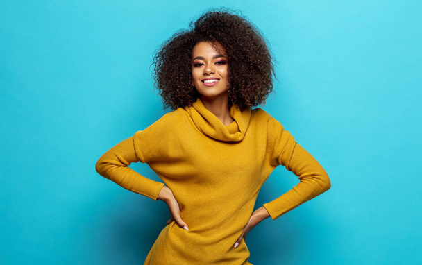 Smiling black woman wear cardigan isolated on blue background - Foto, immagini