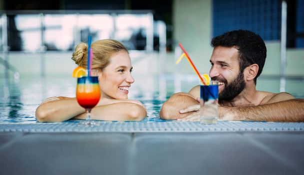 スパ スイミング プールのある魅力的な幸せなカップルのリラックス - 写真・画像