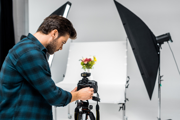 young photographer photographing beautiful flowers in professional photo studio  - Photo, Image