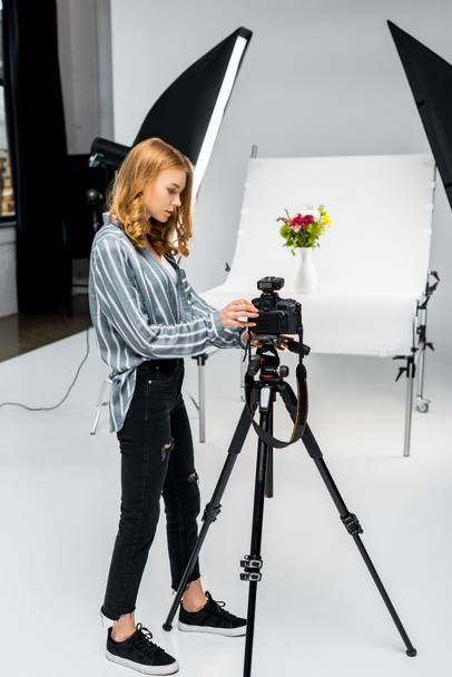 beautiful young female photographer shooting flowers in photo studio - Photo, Image