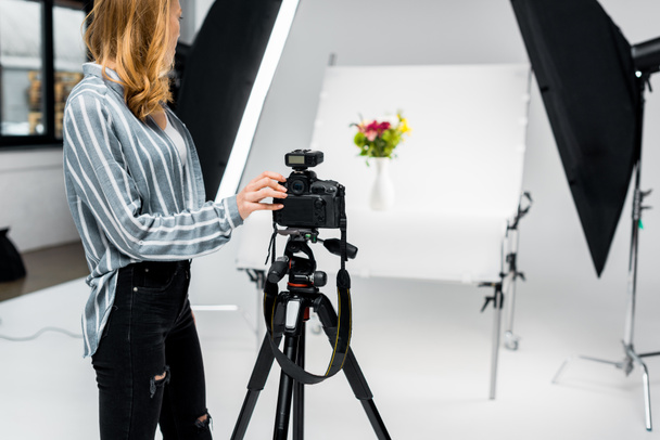 cropped shot of young female photographer shooting flowers in studio - Фото, изображение