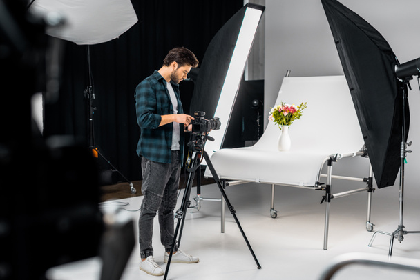 professional young photographer working with camera and lighting equipment in photo studio  - Φωτογραφία, εικόνα