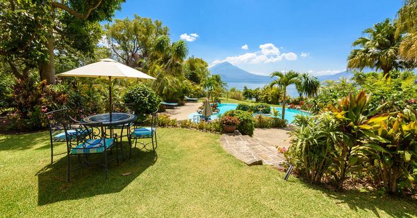 Paradise beach with chair and kayak at lake Atitlan, Panajachel - Relaxing and recreation at beach with vulcano landscape scenery in the highlands of Guatemala - Photo, image