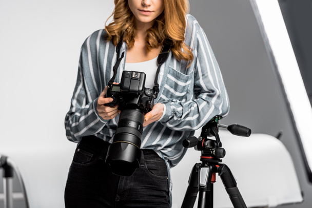 recortado disparo de hermosa mujer joven utilizando la cámara de fotos profesional en el estudio
 - Foto, Imagen
