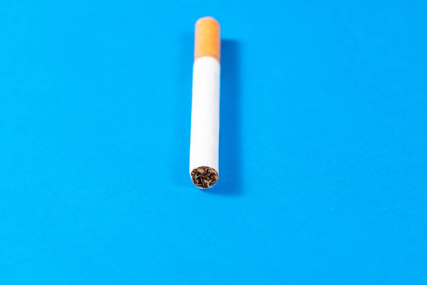 Tobacco Cigarette close up with blue background - Foto, afbeelding