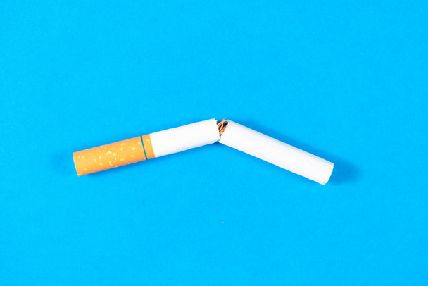 Tobacco Cigarette broken close up with blue background - Foto, afbeelding