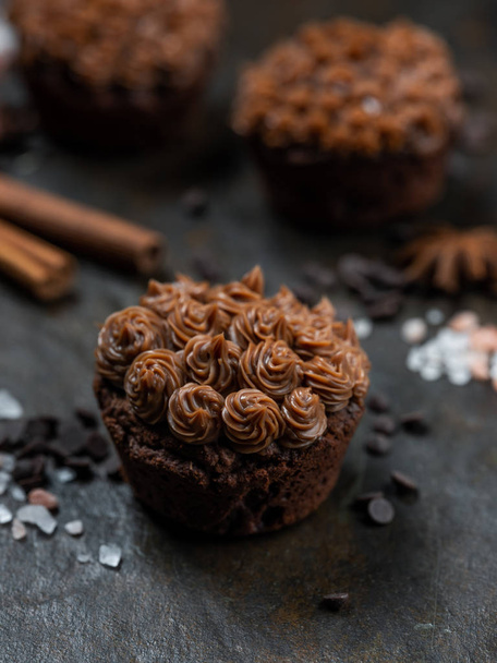 Close view of fresh chocolate cupcakes with salted caramel on dark stone background - Foto, Imagen