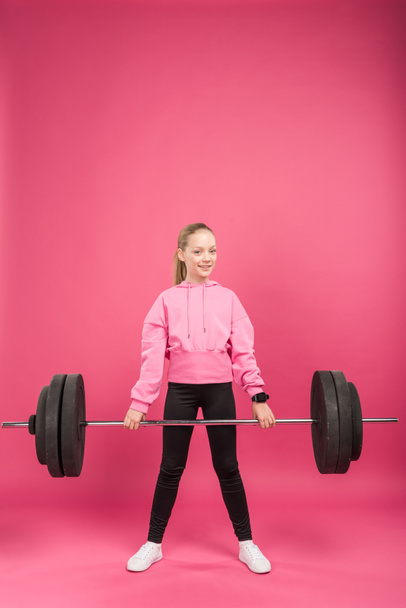 sportive youngster exercising with barbell, isolated on pink - Fotografie, Obrázek