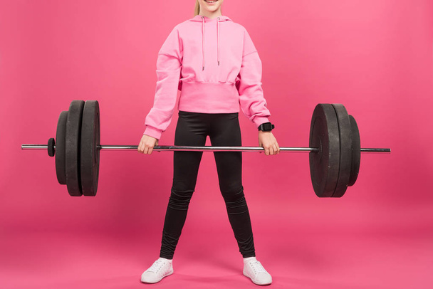 cropped view of youngster training with barbell, isolated on pink - Zdjęcie, obraz