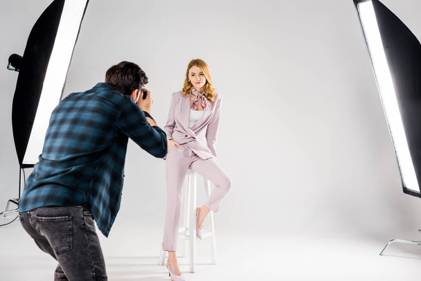 back view of photographer shooting beautiful young female model in studio - Fotografie, Obrázek