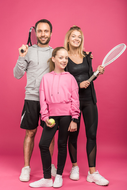 famiglia atletica che tiene racchette da tennis e palla, isolato su rosa
 - Foto, immagini