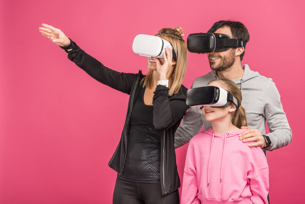 family using virtual reality headsets together, isolated on pink - Фото, зображення