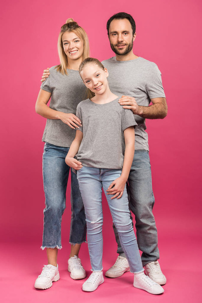 beautiful parents hugging preteen daughter, isolated on pink - Foto, afbeelding