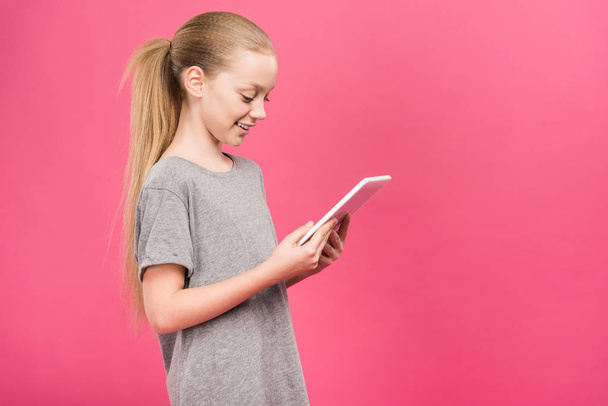 adorable blonde kid using digital device, isolated on pink - Foto, afbeelding