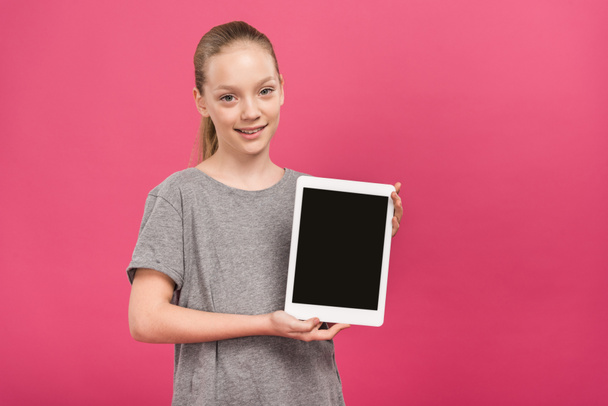 adorable kid presenting digital tablet with blank screen, isolated on pink - Fotó, kép
