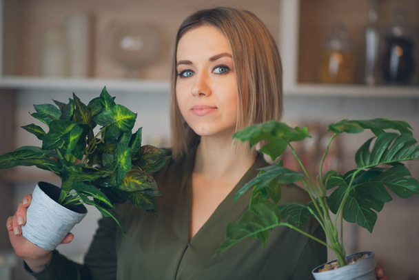 Woman with plants standing indoors - Foto, afbeelding
