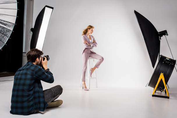 male photographer shooting beautiful stylish young woman in photo studio  - 写真・画像