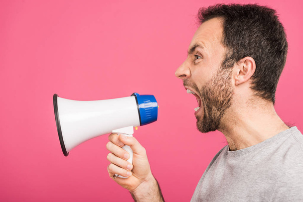 angry man yelling with megaphone, isolated on pink - Foto, Imagem