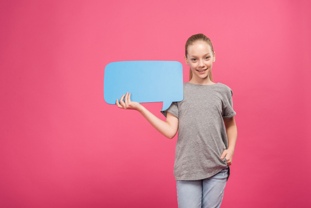 blonde youngster holding blue speech bubble, isolated on pink - 写真・画像