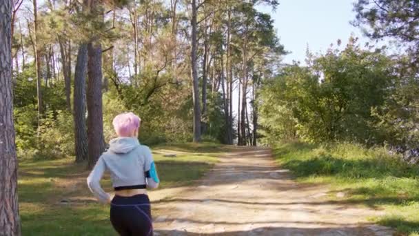 Mladá dáma s růžovými vlasy, běhání v lese - Záběry, video