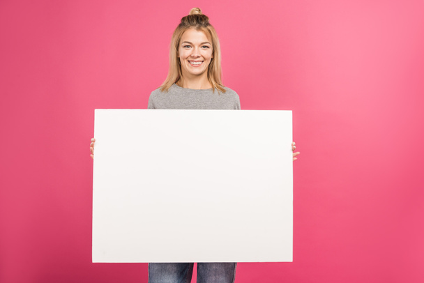 attractive woman holding empty board, isolated on pink - Photo, Image