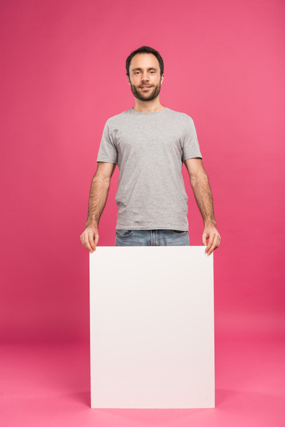handsome man posing with empty board, isolated on pink - Photo, Image