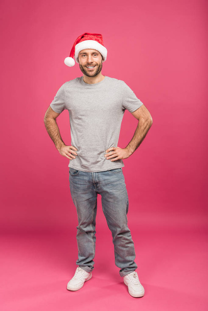 portrait d'homme heureux en chapeau de Père Noël au temps de Noël, isolé sur rose
  - Photo, image