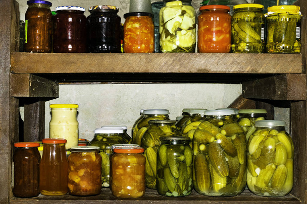 Sklenice nakládané zeleniny, ovocné kompoty a džemy ve sklepě. Konzervovaných potravin - Fotografie, Obrázek