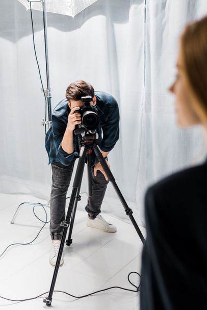 cropped shot of young photographer shooting beautiful female model in studio  - 写真・画像
