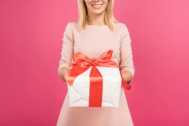 cropped view of woman holding gift box isolated on pink  - Fotó, kép