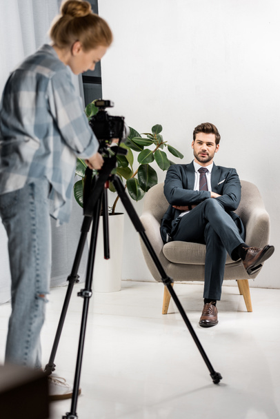 young photographer taking pictures of handsome male model in studio - Foto, imagen