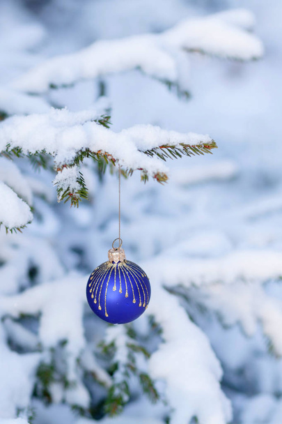 Die schneebedeckte Tanne ist mit Neujahrsspielzeug geschmückt - Foto, Bild