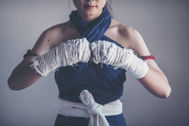 Primo piano mano femminile di pugile con bende da boxe bianche. pugni di combattente prima della lotta o l'allenamento in palestra
 - Foto, immagini