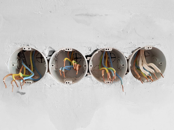 Prises murales électriques multiples avec fils démontés dans un processus de rénovation de la pièce
.  - Photo, image
