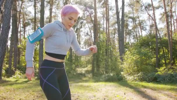 Jeune dame avec des cheveux roses Jogging dans la forêt
 - Séquence, vidéo