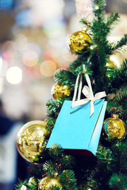 Imagem de abeto de Natal com bolas de ouro, pacote vermelho para presentes
 . - Foto, Imagem