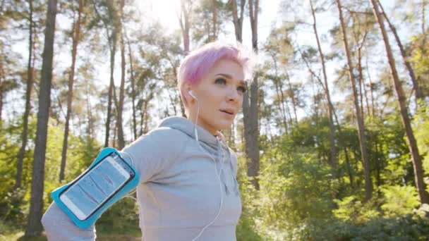 森の中ジョギング ピンクの髪をもつ若い女性 - 映像、動画