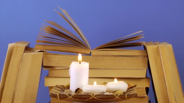 Velas ardientes con libros apilados en la mesa, concepto de educación
. - Metraje, vídeo