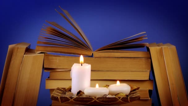Κεριά καύση με στοιβάζονται βιβλία στο τραπέζι, εκπαίδευση έννοια. - Πλάνα, βίντεο