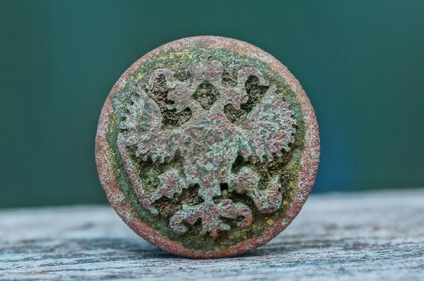 old rusty brown button with eagle on gray table - Photo, Image