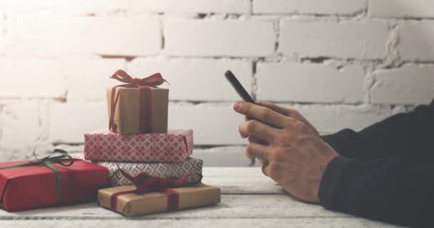 hombre usando el teléfono inteligente para comprar regalos en línea en la tienda de Internet
 - Imágenes, Vídeo