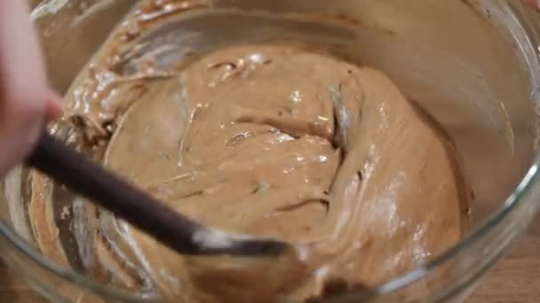 A cukrász lány keverés a tészta a kulináris spatulával csokoládé, keksz torta sütés. házi édességek. - Felvétel, videó
