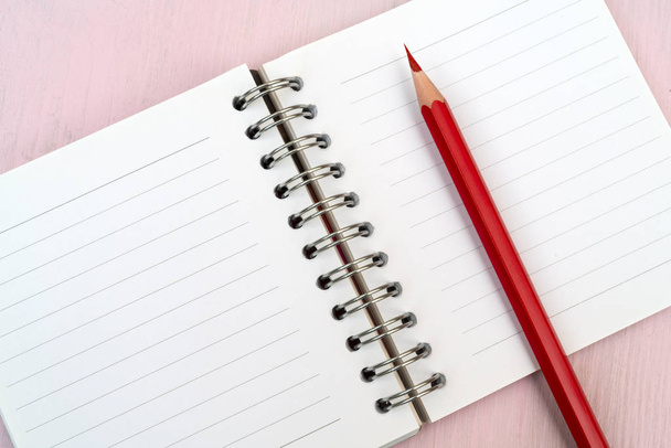 Rood potlood en notebook voor notities. - Foto, afbeelding