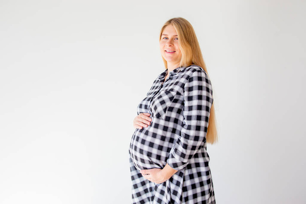 pregnant woman standing on scales to control weight gain - Valokuva, kuva