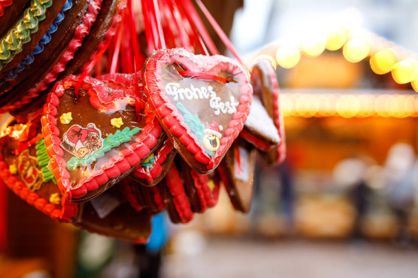 Peperkoek hart op Duitse kerstmarkt. Neurenberg, München, Berlijn, Hamburg xmas markt in Duitsland. Op traditionele gember brood genaamd cookies geschreven Merry Chrismtas Lebkuchen in Duits - Foto, afbeelding