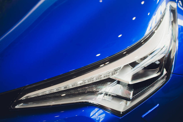Close up shot of headlight in luxury blue car background. Modern and expensive sport car concept - Foto, imagen