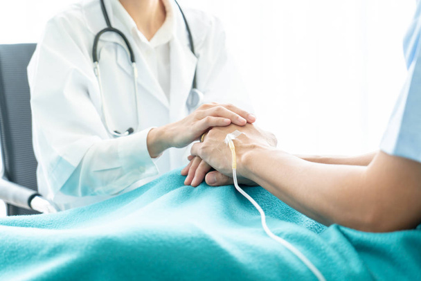Hand of female doctor reassuring on her senior patient - selective focus point - Foto, Imagen