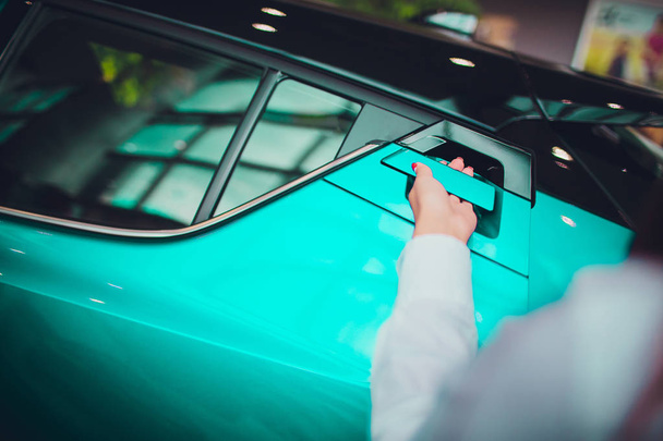 жіноча рука для вставки задніх дверей відкритого автомобіля бежевого кольору. для транспорту та автомобільного зображення
 - Фото, зображення